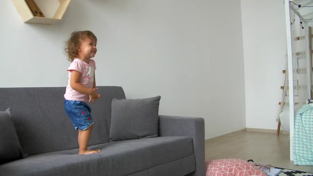 Little Girl Jumping On The Couch