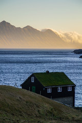 Scenic landscape view of traditional historic wooden house/building with grass (turf) roof in the Gjógv village, Eysturoy Island. Tourist popular attraction/place in Faroe Islands (Denmark)
