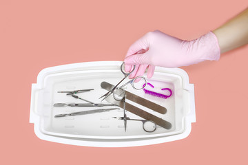 Manicure tool in the hands of the master. Close up. predsterilizatsionnoy cleaning. disinfection of...