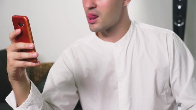 a man using his smartphone. looking through erotic content. he flirts talking on video