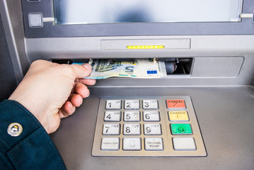 Happy person taking euro money from ATM bank machine. Payday concept.
