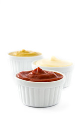 Ketchup,mustard and mayonnaise in a bowls isolated on white background