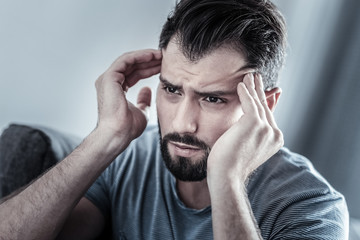 Fototapeta premium Exhausted bearded male person looking forward