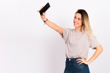 Girl on white with cell phone smiling using  internet social media concept 