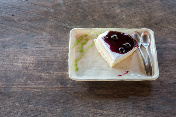 Delicious blueberry cheesecake. Blue berry cake slices on wood plate. Blueberry cheese cake in dish on the wood table
