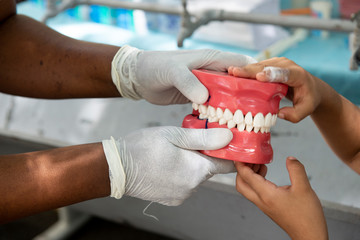 Rio de Janeiro, Brazil - november 22, 2018: Health professional teaches how to floss with a dental arch replica