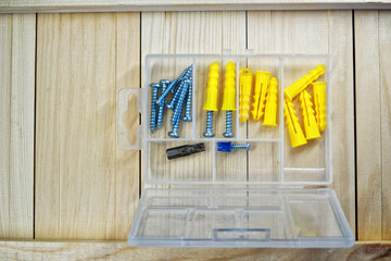 Screws and dowels lie on the boards. Box-organizer for the carpenter