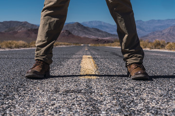 Man's legs on road between death lands