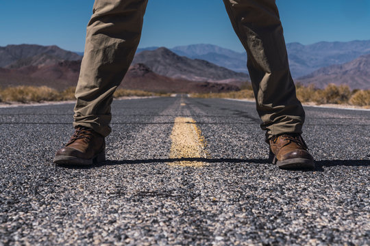 Man's legs on road between death lands