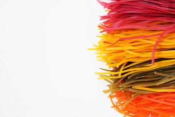 Raw colored spaghetti on white clean background