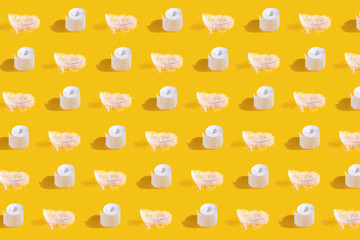 Top view of Rolls of toilet paper, seamless photographic pattern. Repetitive pattern with shadow on yellow background, flat lay.