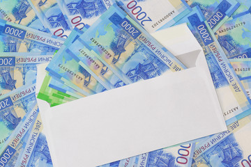 White envelope with money on the background of the new Russian two thousandth bills
