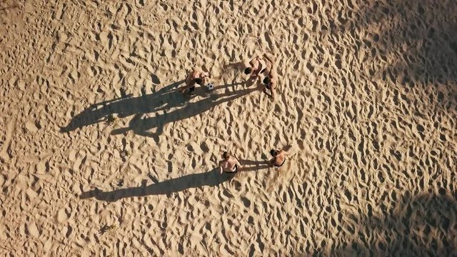 Sport Soccer players in dynamic action funny play on the sand in beach football in summer sunny day under sunlight.
