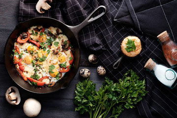 Fried eggs with bacon, mushrooms, bell peppers and greens