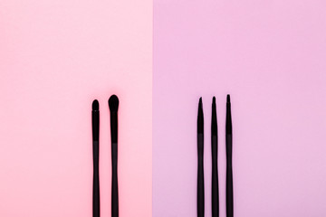 makeup brushes on pastel paper pink background