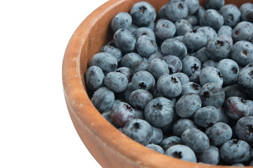 closeup blueberry in wooden bowl. isolated.