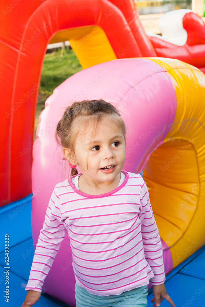 Wall mural A cheerful child plays in an inflatable castle