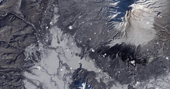 Vertical aerial ascent through light falling snow, over Kamchatka Peninsula, Russia. Elements of this image furnished by NASA. 
