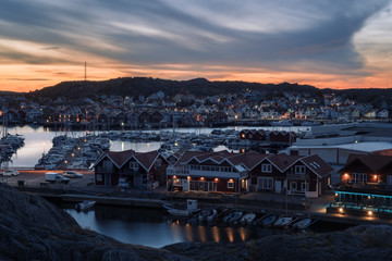 View at the harbor with a coastal city on an island at sunset.