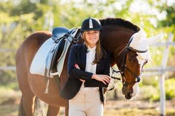 Girl equestrian rider stands near the horse. Horse farm. Horse theme  