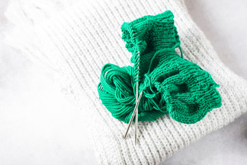 Fototapeta na wymiar Green knitting yarn and knitting needles close-up.