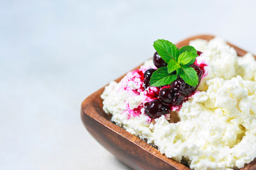 Homemade cottage cheese in a wooden bowl, diet concept.