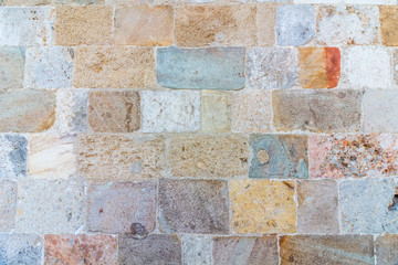 Stone wall texture in good condition. Orange, blue, yellow, brown and red colors