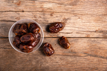 Dried date palm in cup on wooden floor.(Phoenix dactylifera Linn.)
