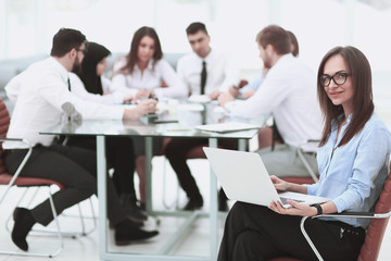 Executive businesswoman with laptop on blurred background business team