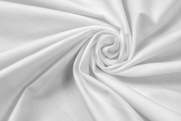 White sateen fabric is draped with diagonal folds in the form of a spiral