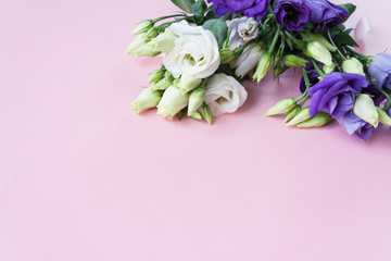 Frame of purple white Lisianthus on pink background.