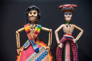 calaveras de dia de muertos  multicolores, dia de muertos con huesos y figuras de papel y barro...