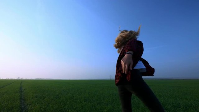 Beauty young blondie girl running on green wheat field over sunset sky. Freedom concept. Happy woman outdoors. Harvest. Wheat field in sunset. Slow motion 120 fps. Slowmo.