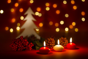 Fototapeta na wymiar Christmas candles and ornaments over dark background with lights