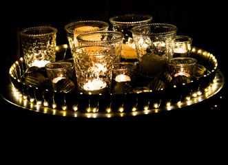 detail view of a decorative and festive Christmas holiday arrangement with glasses and candles and assorted decorative articles at night