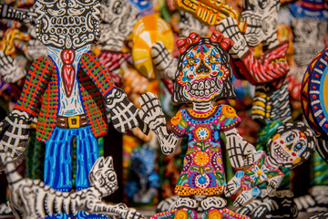 figuras coloridas de calaveras con tocados de flores y sonrisas