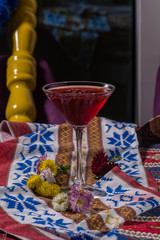 Red cosmopolitan cocktail in martini glass, on colorful background