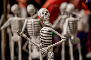 Fototapeta na wymiar calaveras de dia de muertos multicolores, dia de muertos con huesos y figuras de papel y barro tradicional mexicano