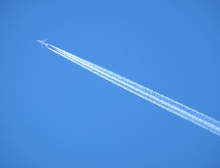 Big with two jet engines passenger supersonic plane flying high in clear cloudless blue sky,...