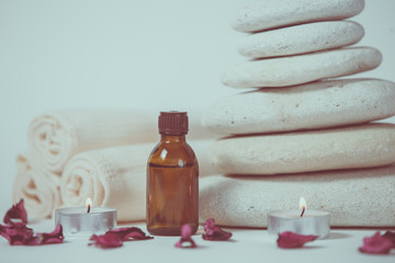 Spa still life with towels, stones, bath oil and candle