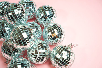 Silver disco balls for decoration party on pastel pink gradient background. Winter New Years Eve party holiday concept. top view, flat lay close up mirror ball. Frame with room for copy.