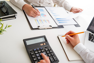 Business team two colleagues discussing new plan financial graph data on office table