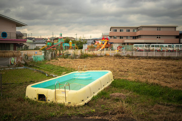 Small above ground pool fallen into disuse outside children's playground