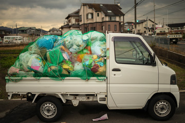 Small Japanese flatbed truck packed with garbage before heading to dump