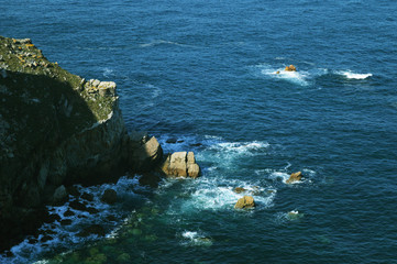 Huge stones and waves of the Cantabrian Sea near palaeozoic rock formations from the Cabo de Penas in Asturias, Spain