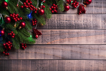 Christmas background concept. Top view of Christmas spruce branches, red berries and bell on old wooden background.