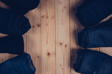 Roll Frayed jeans or blue jeans denim collection on rough wooden table background with copy space, old fashion concept.