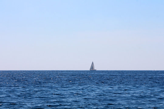 Small Sailing Boat Alone On The Horizon Line