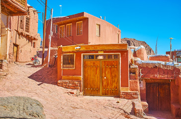 The narrow curved street leads to the mountain top, running among the restored old red-ochre houses...
