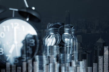 Double exposure of coin stack and alarm clock with city background and financial graph, business finance concept.